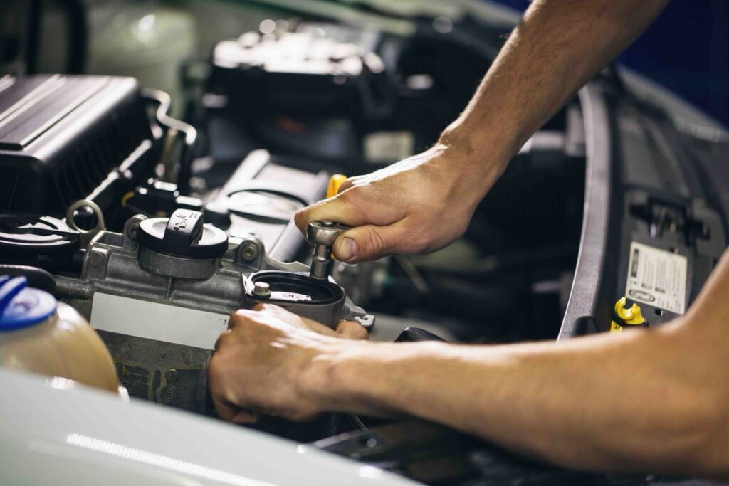 hands of man setting the engine of car